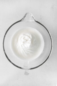 whipped cream in a glass bowl on a white background.