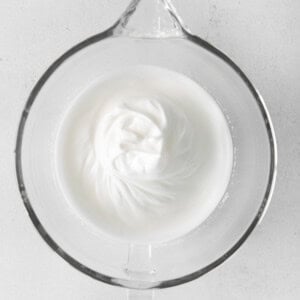 whipped cream in a glass bowl on a white background.