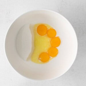 three eggs in a bowl on a white surface.