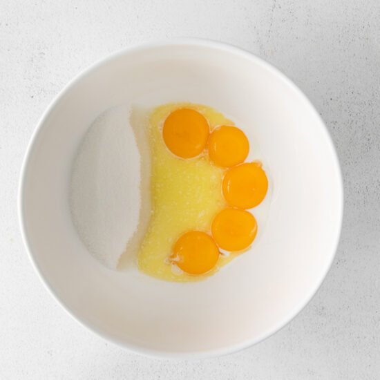 three eggs in a bowl on a white surface.