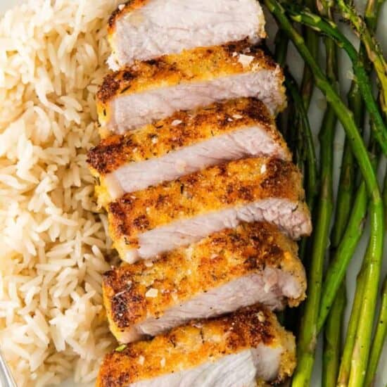 Parmesan Crusted Pork Chops on a plate with rice and asparagus