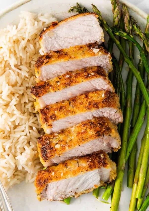 Parmesan Crusted Pork Chops on a plate with rice and asparagus