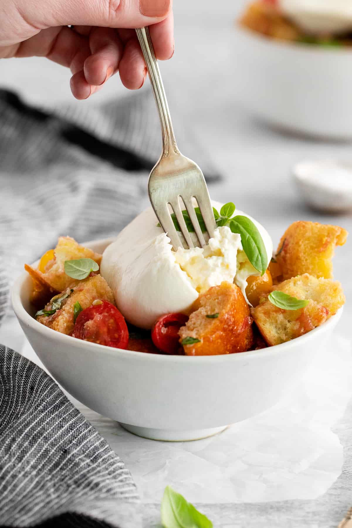 A fork taking a bite of panzanella salad. 