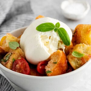 Panzanella salad with burrata in a bowl.