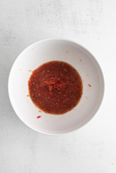 Prepare the grated tomato sauce in a mixing bowl.