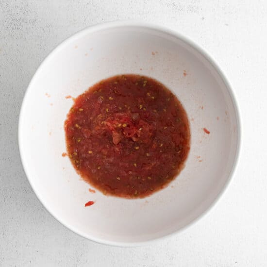 Prepare the grated tomato sauce in a mixing bowl.