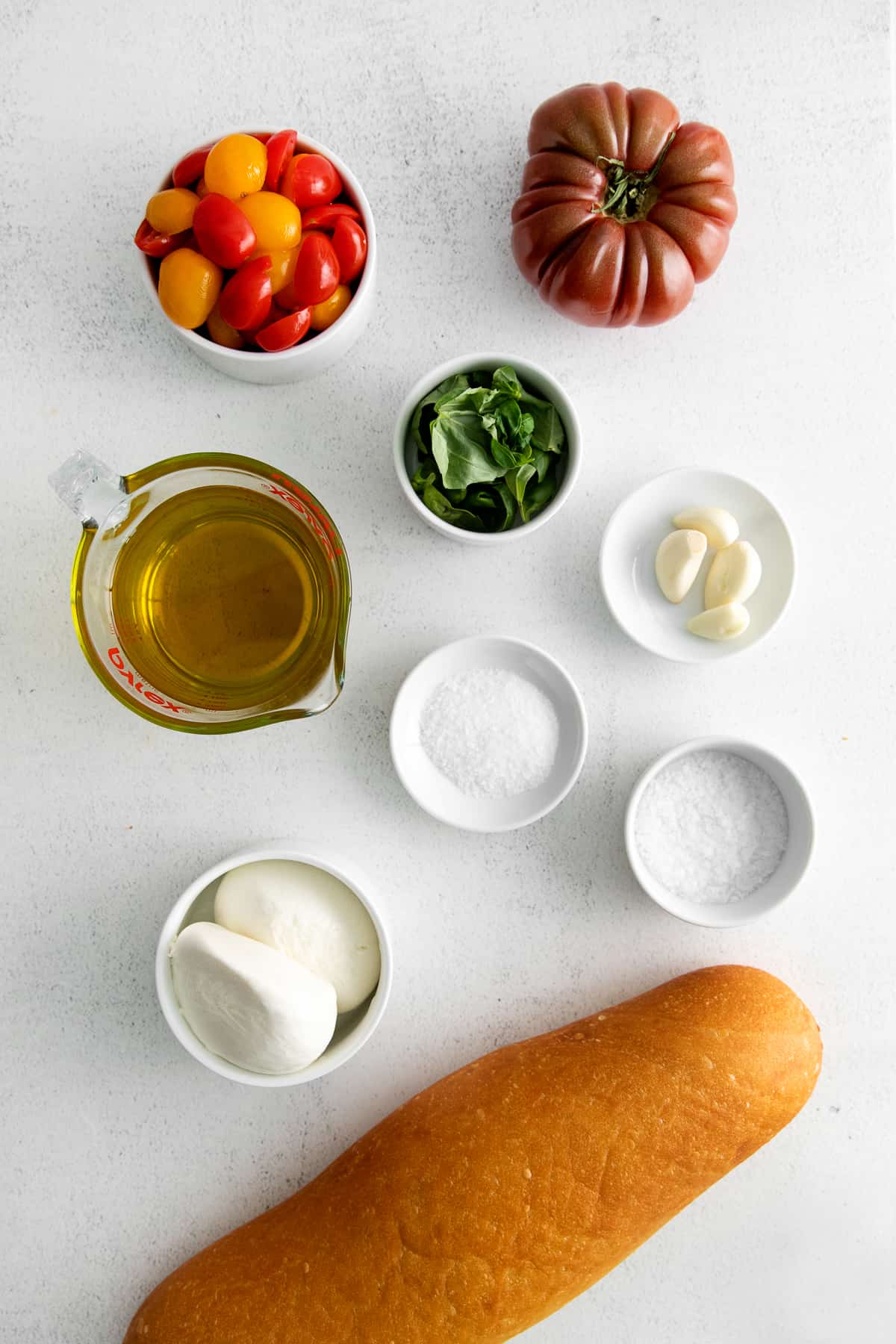 All of the ingredients for the panzanella salad in small bowls. 