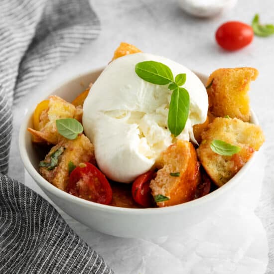 Panzanella salad with burrata in a bowl.