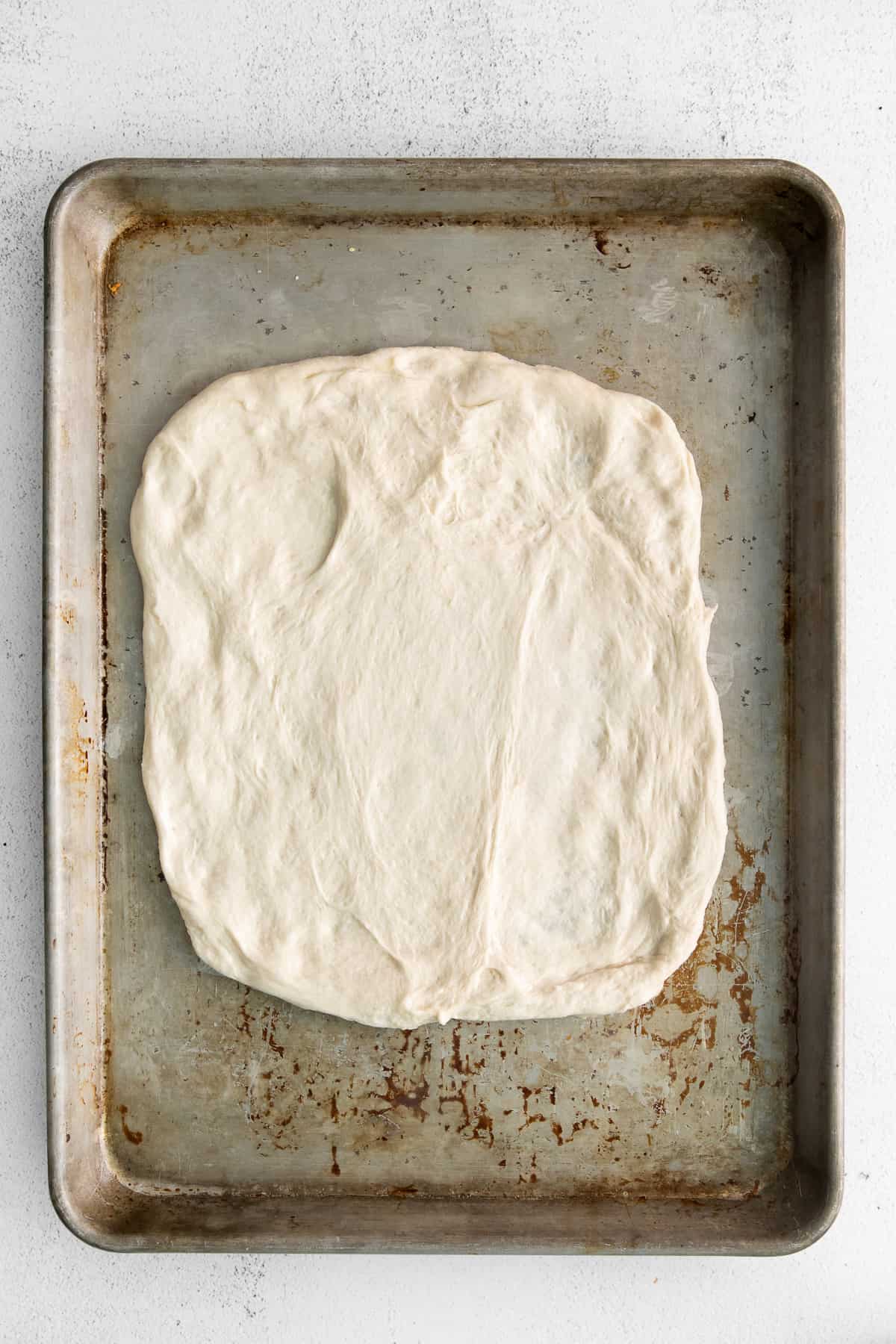 Cheese bread dough on a baking sheet.