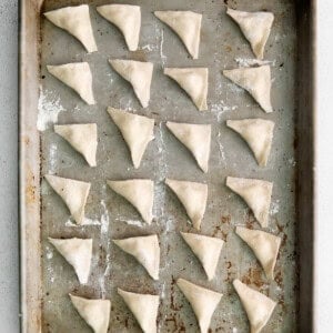 Folded cheese tortellini on a pan.