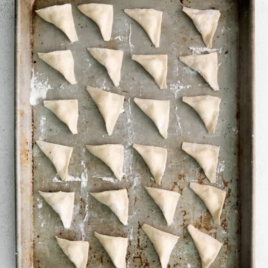 Folded cheese tortellini on a pan.