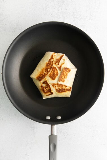 a pancake in a frying pan on a white background.