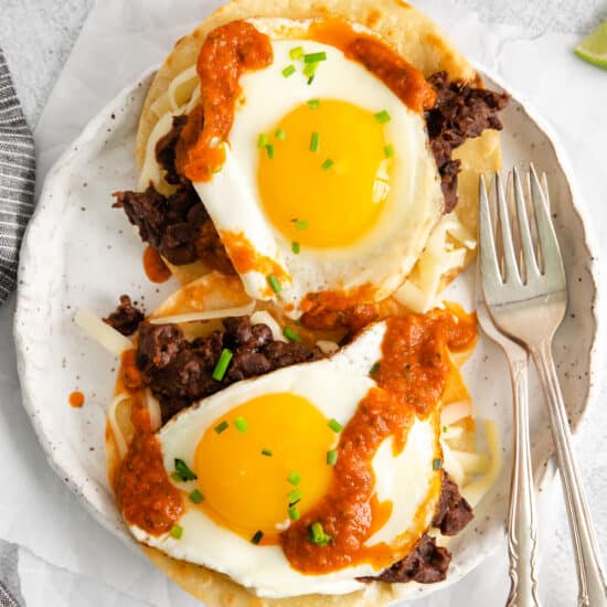 a plate of mexican breakfast tacos with an egg on top.
