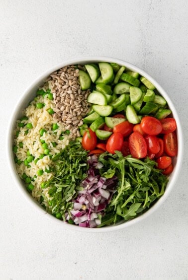 a white bowl filled with vegetables and rice.