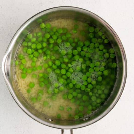peas in a pan on a white surface.