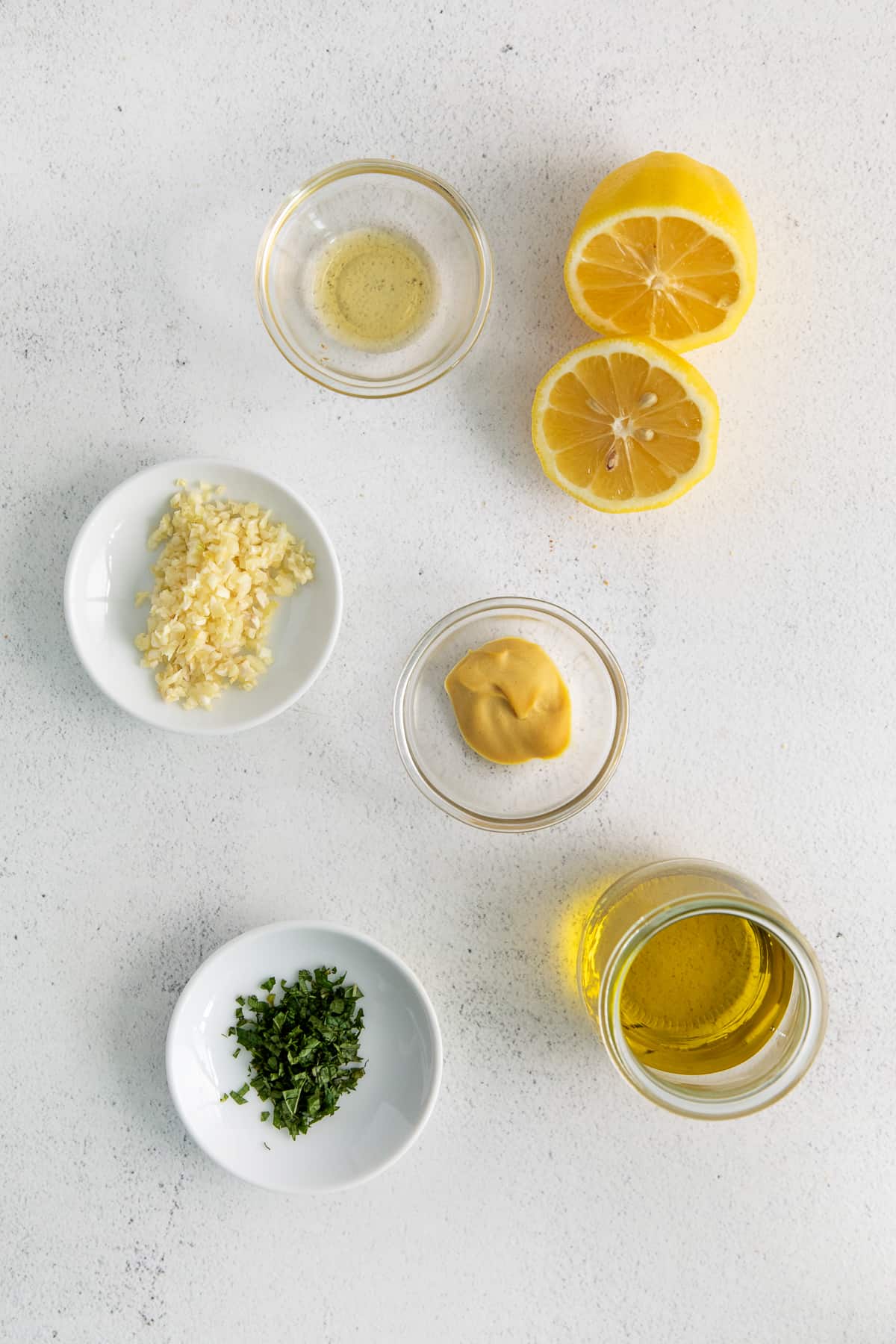 Ingredients for lemon vinaigrette in bowls.