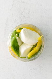 Goat cheese, lemon, and basil in a jar.