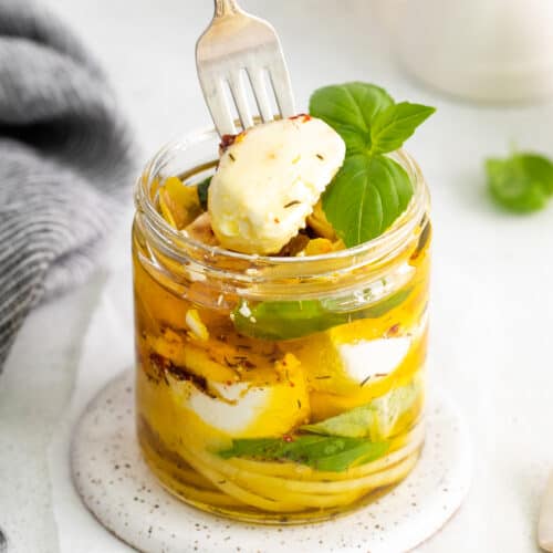 Taking a piece of goat cheese out of the jar.