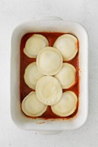 stuffed ravioli in a white baking dish.