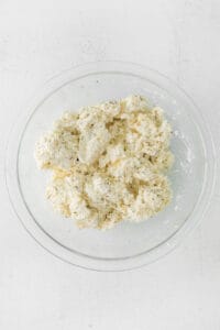 cauliflower in a glass bowl on a white surface.