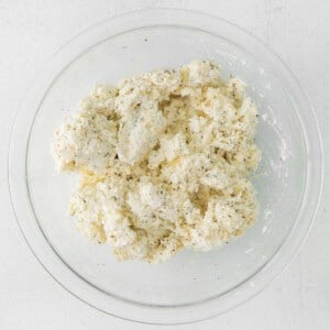 cauliflower in a glass bowl on a white surface.