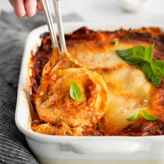 lasagna in a white dish with a fork in it.