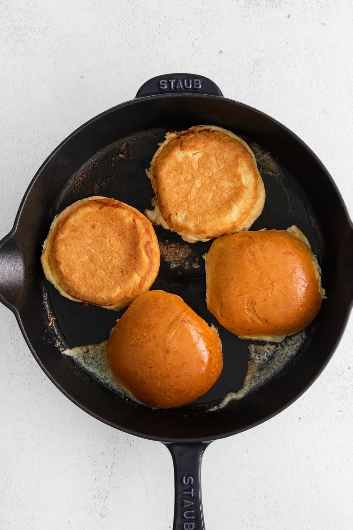 Cheeseburger buns in a cast iron skillet