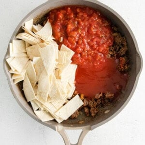 a frying pan with meat, salsa, and tortilla chips.