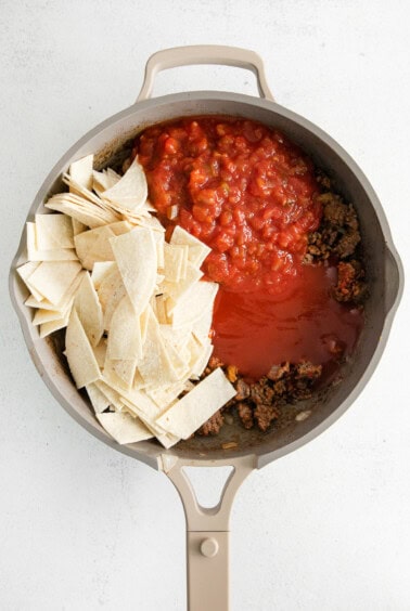 a frying pan with meat, salsa, and tortilla chips.