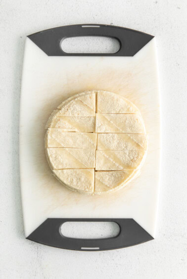 a tortilla on a cutting board on a white background.