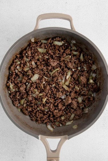 Ground beef and onion in a skillet.