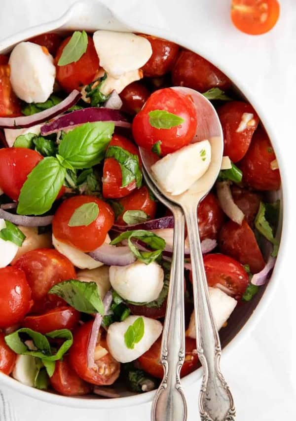 salad in bowl with spoons.