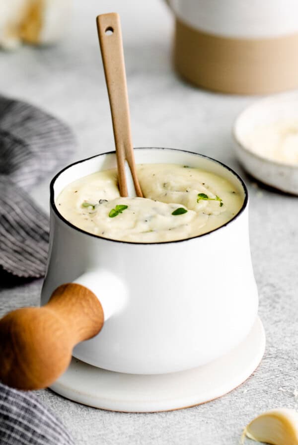 A small pot of garlic parmesan sauce.