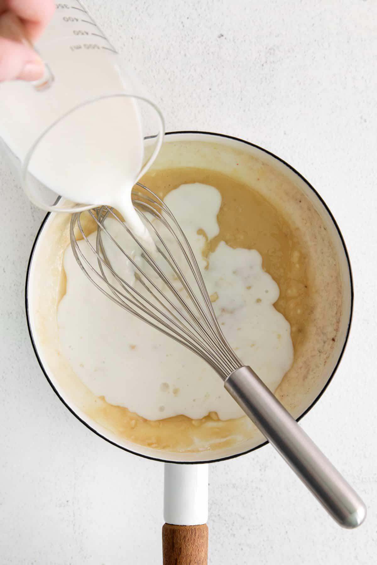 Pouring milk into a saucepan.