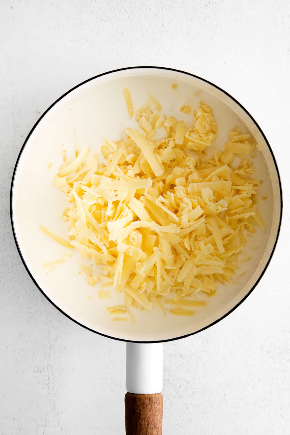 adding cheese to pot.
