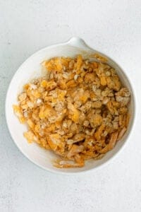 a white bowl filled with shredded cheese and granola.