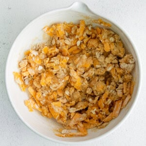 a white bowl filled with shredded cheese and granola.