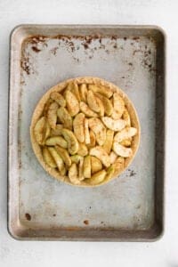 a pie with apples on a metal pan.