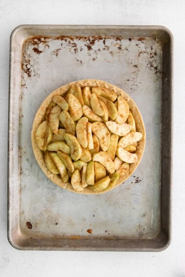 a pie with apples on a metal pan.