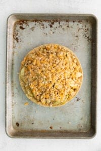 a pie on a baking sheet with toppings on it.