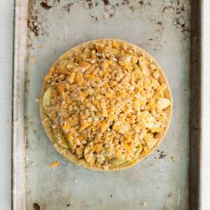 a pie on a baking sheet with toppings on it.