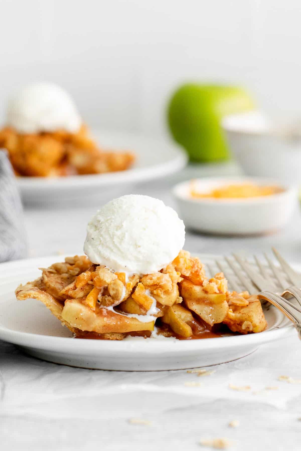 Slice of apple pie with cheese on a plate.