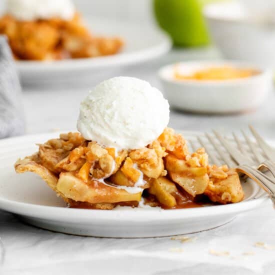 apple pie with ice cream on a plate.