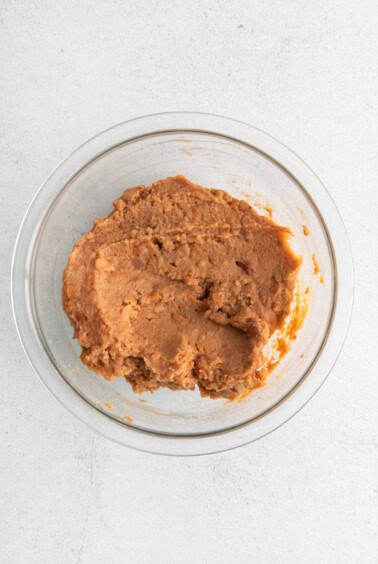 peanut butter in a glass bowl on a white background.