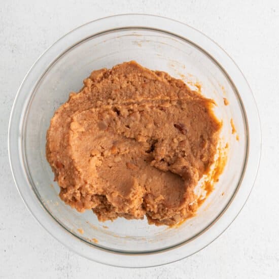 peanut butter in a glass bowl on a white background.