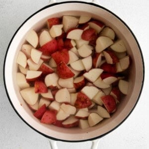 a pot full of sliced potatoes in a white background.