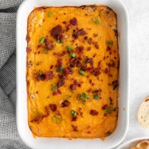 a white dish with a dip and bread on it.