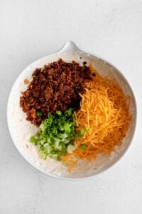 a white bowl filled with ingredients for a taco salad.