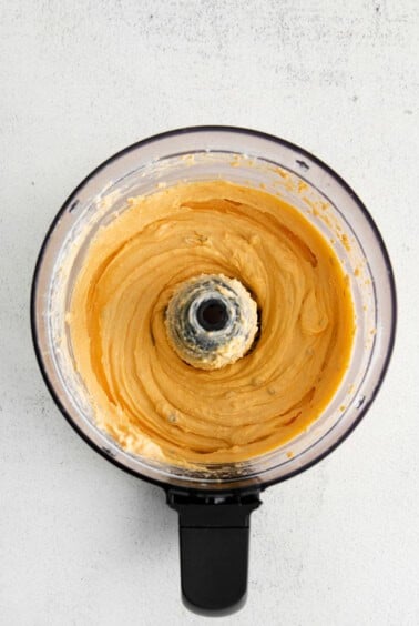 a food processor filled with a yellow batter.