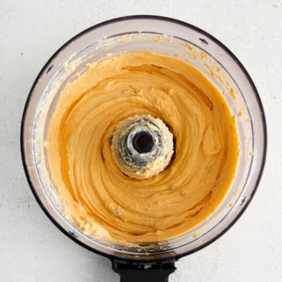 a food processor filled with a yellow batter.